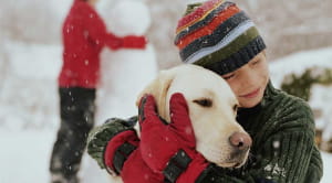 Protect your home and pets this winter child hugging dog snow